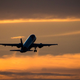 A photo of a plane taking off at sunset.